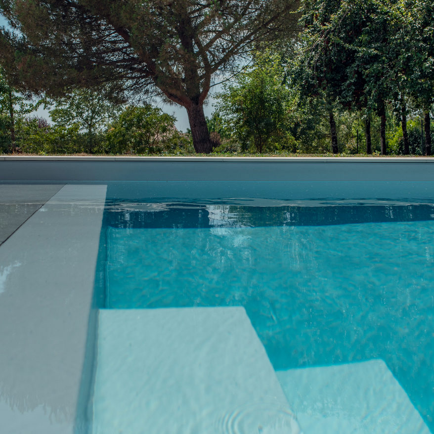 Réalisation Piscines & Concept - Piscine traditionnelle - membrane gris - escalier - volet roulant immergé