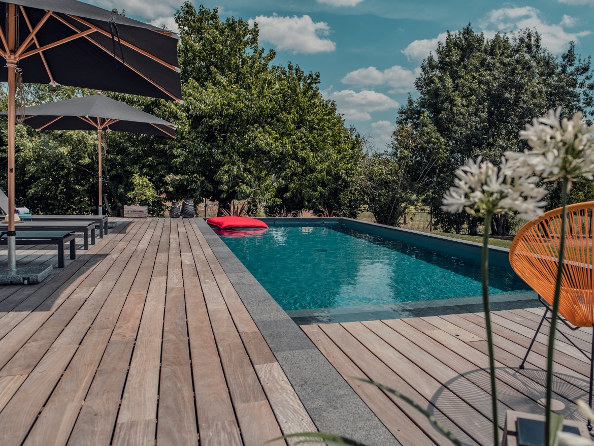 Réalisation Piscines & Concept - Piscine traditionnelle avec escalier - Terrasse bois exotique